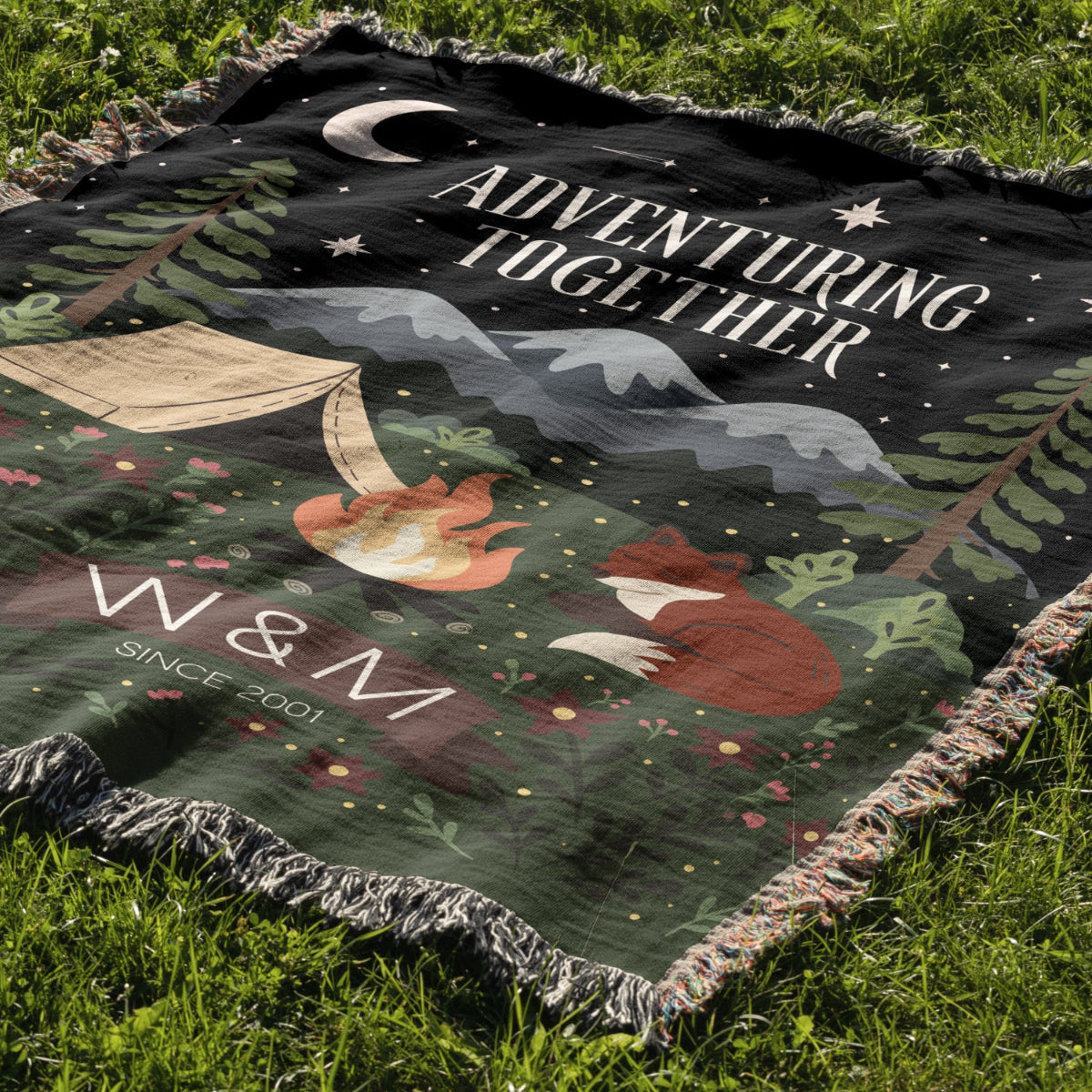 Blanket with foxes, camping scene, and 'Adventuring Together' text on grass