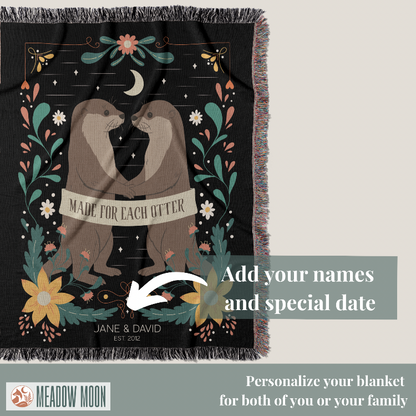 Blanket with two otters holding hands and floral design, featuring text 'Made for each other' and 'Meadow Moon' branding.